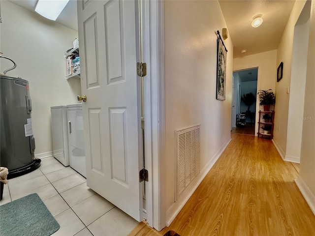 3828 6th Ave W, Palmetto, FL 34221 - laundry area featuring water heater, baseboards, and light wood-type flooring