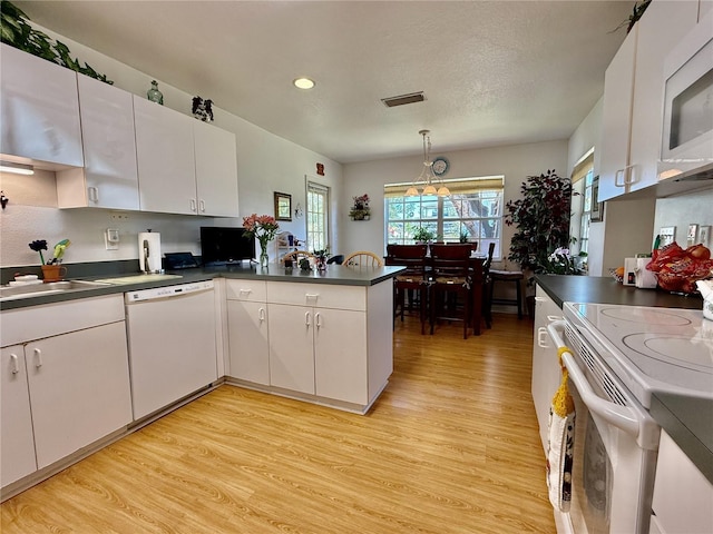 3828 6th Ave W, Palmetto, FL 34221 - kitchen featuring white appliances, light wood-style flooring, dark countertops, a peninsula, and recessed lighting