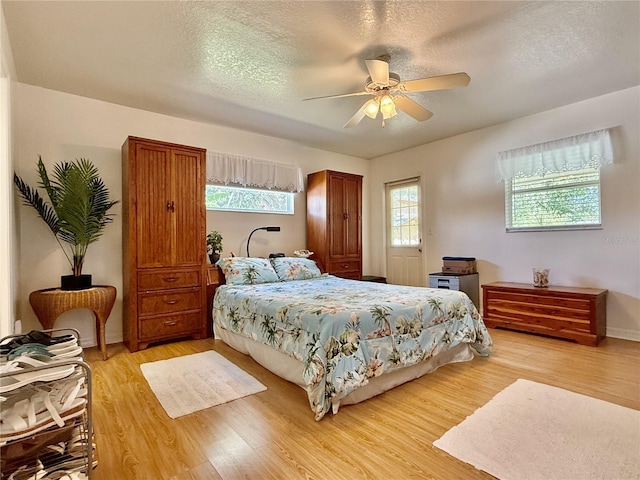 3828 6th Ave W, Palmetto, FL 34221 - bedroom featuring light wood finished floors, a textured ceiling, and a ceiling fan