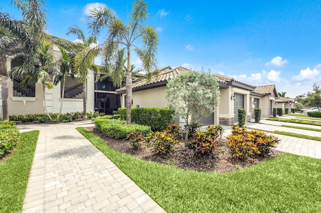 5624 Palmer Cir Unit 206, Bradenton, FL 34211 - view of front of house with stucco siding, an attached garage, a tiled roof, and stone siding