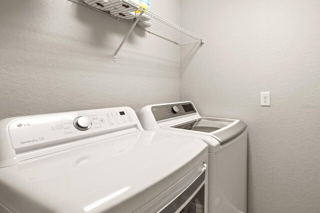 5624 Palmer Cir Unit 206, Bradenton, FL 34211 - washroom featuring separate washer and dryer and a textured wall
