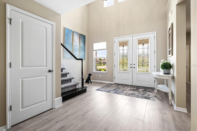 8272 Summer Night Rd, Sarasota, FL 34241 - entrance foyer featuring wood finished floors, stairs, french doors, baseboards, and a towering ceiling