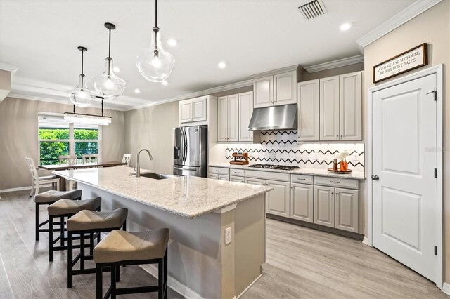 8272 Summer Night Rd, Sarasota, FL 34241 - kitchen with a sink, under cabinet range hood, stainless steel appliances, ornamental molding, and an island with sink