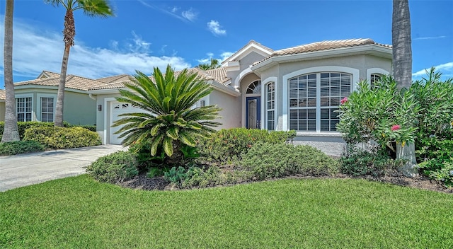 4220 Miriana Way, Sarasota, FL 34233 - view of front of property with an attached garage, stucco siding, a tile roof, and a front lawn