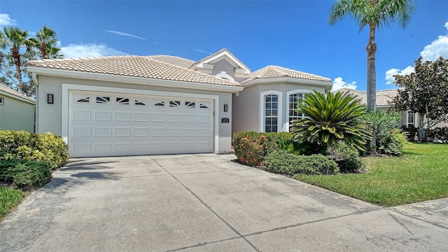 4220 Miriana Way, Sarasota, FL 34233 - mediterranean / spanish-style house with an attached garage, stucco siding, a tiled roof, and concrete driveway