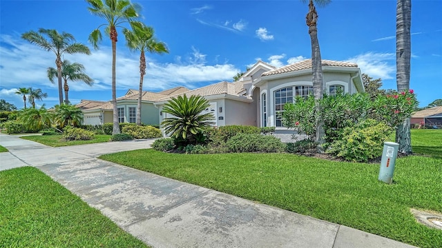 4220 Miriana Way, Sarasota, FL 34233 - mediterranean / spanish-style house featuring driveway, stucco siding, a front yard, and a tiled roof