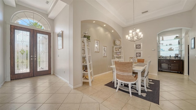 4220 Miriana Way, Sarasota, FL 34233 - dining space featuring french doors, a chandelier, light tile patterned floors, arched walkways, and crown molding