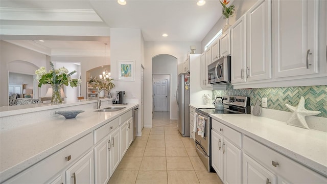 4220 Miriana Way, Sarasota, FL 34233 - kitchen with appliances with stainless steel finishes, a sink, white cabinets, tasteful backsplash, and light tile patterned floors