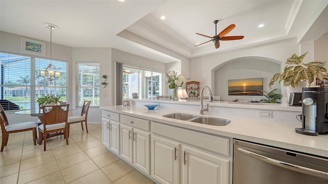 4220 Miriana Way, Sarasota, FL 34233 - kitchen with dishwasher, a sink, a tray ceiling, light tile patterned floors, and white cabinetry
