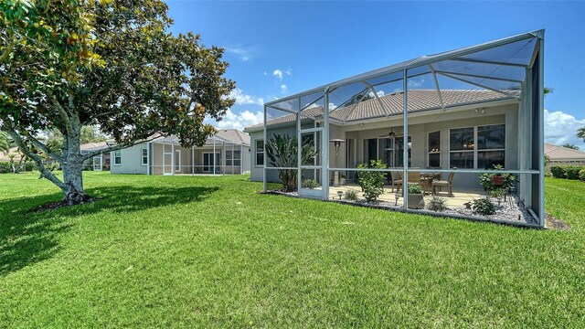4220 Miriana Way, Sarasota, FL 34233 - rear view of house with a ceiling fan, a patio, a lawn, and glass enclosure