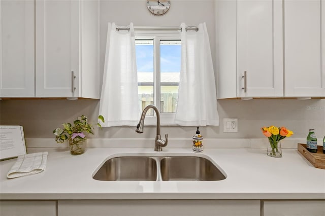 1040 Hope St, Venice, FL 34285 - kitchen with a sink, white cabinetry, and light countertops