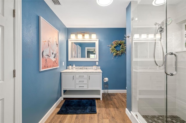 1040 Hope St, Venice, FL 34285 - bathroom featuring a shower stall, vanity, wood finished floors, and baseboards