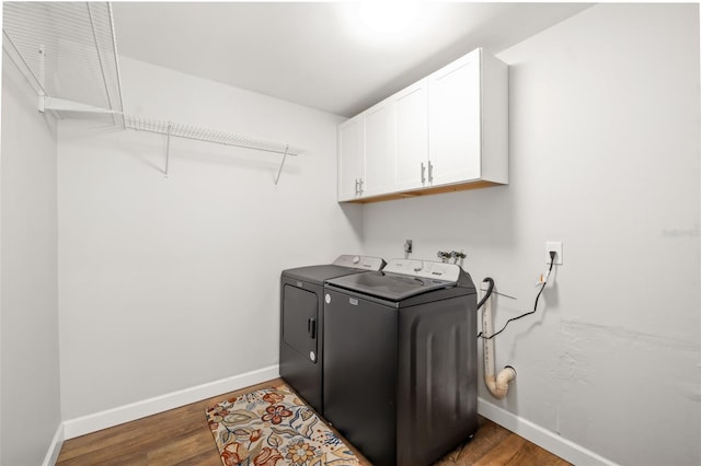 1040 Hope St, Venice, FL 34285 - laundry room with cabinet space, washer and clothes dryer, baseboards, and wood finished floors