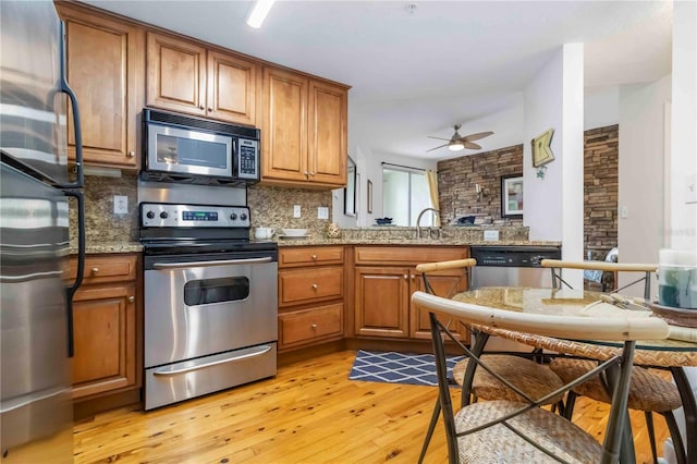 5401 Bentgrass Dr Unit 1-113, Sarasota, FL 34235 - kitchen with appliances with stainless steel finishes, backsplash, brown cabinetry, and ceiling fan