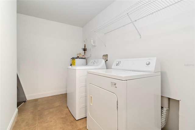 5401 Bentgrass Dr Unit 1-113, Sarasota, FL 34235 - washroom with washing machine and clothes dryer, light tile patterned floors, baseboards, and water heater
