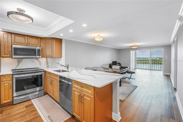 9393 Midnight Pass Rd Unit 603, Sarasota, FL 34242 - kitchen with appliances with stainless steel finishes, a sink, a peninsula, crown molding, and recessed lighting