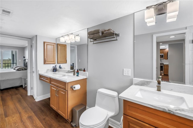 9393 Midnight Pass Rd Unit 603, Sarasota, FL 34242 - ensuite bathroom featuring two vanities, wood finished floors, and toilet