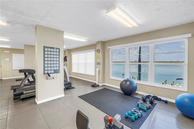 9393 Midnight Pass Rd Unit 603, Sarasota, FL 34242 - exercise room with a textured ceiling, baseboards, and tile patterned flooring
