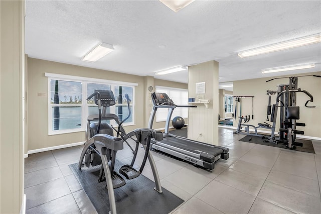 9393 Midnight Pass Rd Unit 603, Sarasota, FL 34242 - exercise room with a textured ceiling, baseboards, and tile patterned flooring