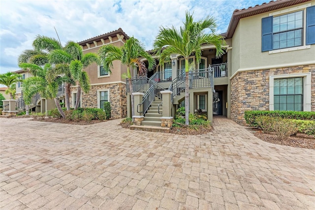 13711 Messina Loop Unit 102, Lakewood Ranch, FL 34211 - view of front of property featuring stairway, stone siding, stucco siding, and a porch