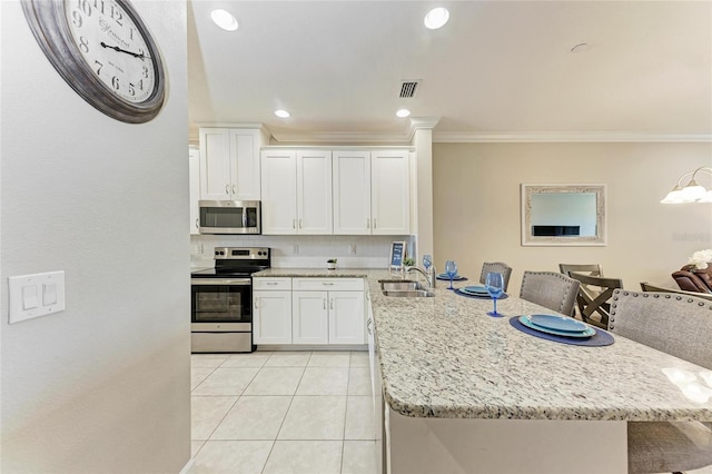 13711 Messina Loop Unit 102, Lakewood Ranch, FL 34211 - kitchen featuring stainless steel appliances, a sink, a peninsula, ornamental molding, and white cabinets