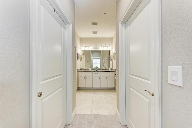 13711 Messina Loop Unit 102, Lakewood Ranch, FL 34211 - hallway with light tile patterned flooring, a textured wall, and light carpet