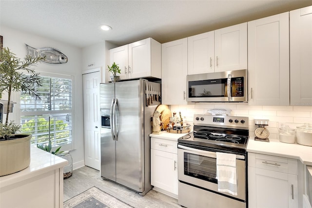 4727 Sabal Key Dr Unit 4727, Bradenton, FL 34203 - kitchen with appliances with stainless steel finishes, light countertops, decorative backsplash, white cabinets, and recessed lighting