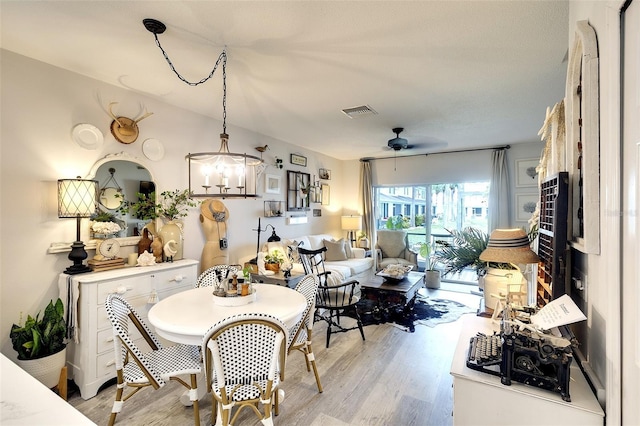 4727 Sabal Key Dr Unit 4727, Bradenton, FL 34203 - dining room with light wood-style flooring, ceiling fan, and a chandelier
