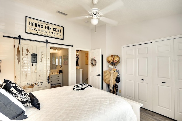 4727 Sabal Key Dr Unit 4727, Bradenton, FL 34203 - bedroom featuring a closet, a barn door, wood finished floors, a ceiling fan, and ensuite bath