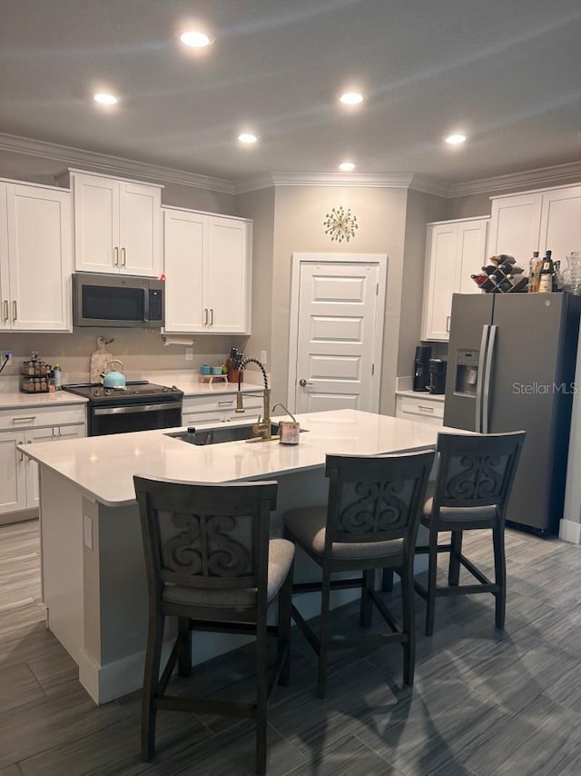 9808 Campanula Ct, Land O Lakes, FL 34637 - kitchen featuring appliances with stainless steel finishes, a sink, a breakfast bar, crown molding, and white cabinets