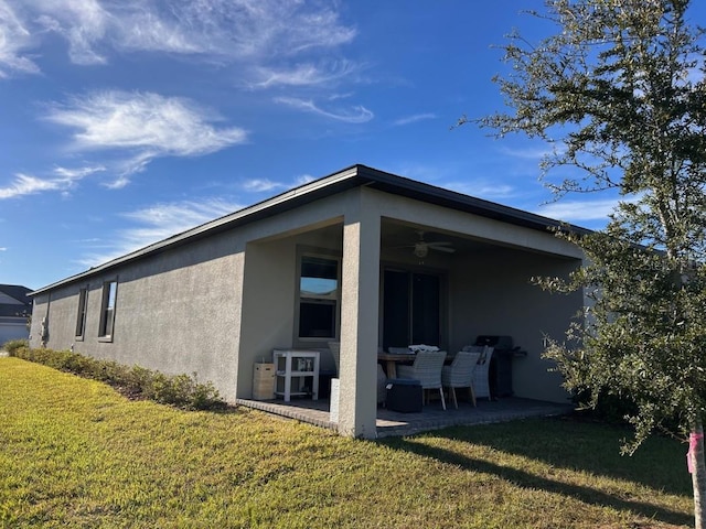 9808 Campanula Ct, Land O Lakes, FL 34637 - rear view of house featuring stucco siding, a patio, a yard, and ceiling fan
