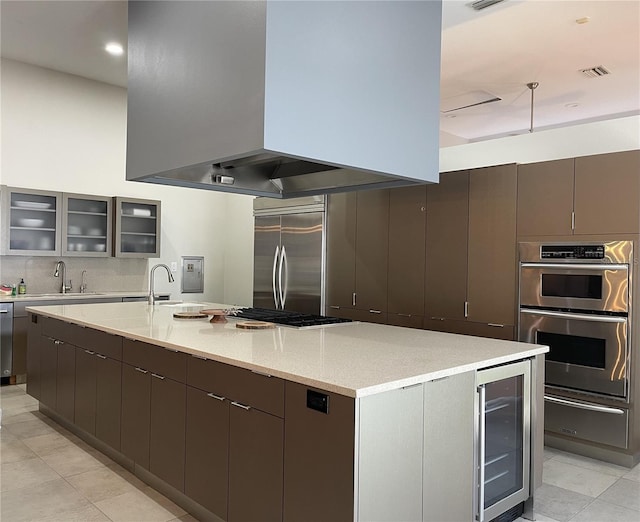 1345 2nd St, Sarasota, FL 34236 - kitchen featuring wall chimney range hood, appliances with stainless steel finishes, a warming drawer, beverage cooler, and a sink
