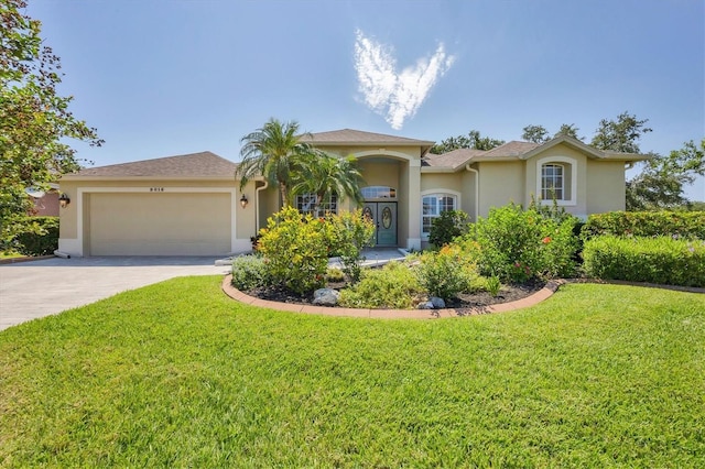 9016 30th St E, Parrish, FL 34219 - mediterranean / spanish-style home with stucco siding, an attached garage, concrete driveway, and a front yard