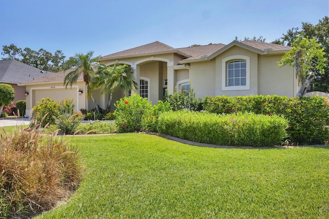9016 30th St E, Parrish, FL 34219 - mediterranean / spanish-style home featuring stucco siding, an attached garage, a front lawn, and concrete driveway