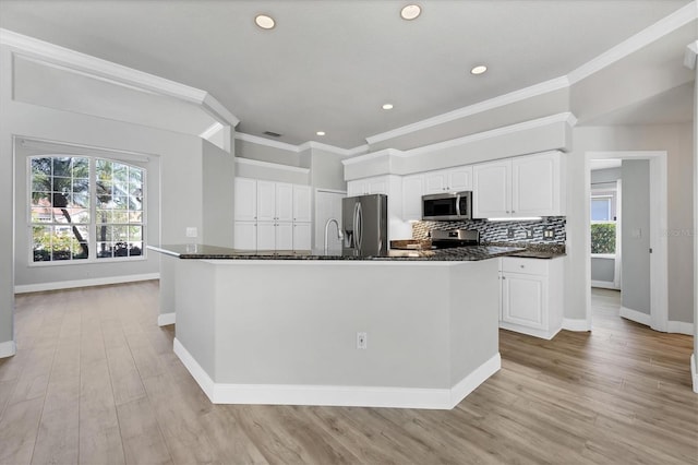 9016 30th St E, Parrish, FL 34219 - kitchen featuring appliances with stainless steel finishes, baseboards, healthy amount of natural light, light wood-style flooring, and crown molding