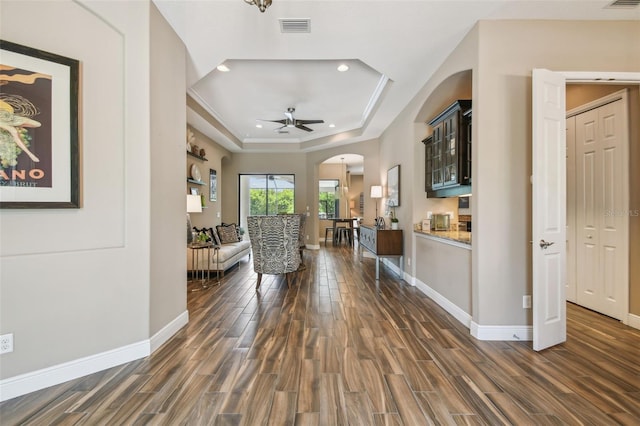 16246 26th St E, Parrish, FL 34219 - living area with arched walkways, a raised ceiling, dark wood finished floors, baseboards, and recessed lighting