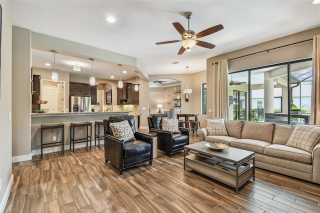 16246 26th St E, Parrish, FL 34219 - living area with a ceiling fan, wood finish floors, baseboards, recessed lighting, and arched walkways