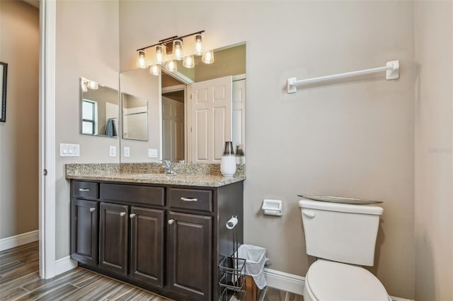 16246 26th St E, Parrish, FL 34219 - bathroom with toilet, vanity, baseboards, and wood finished floors