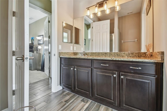16246 26th St E, Parrish, FL 34219 - bathroom featuring wood finish floors, vanity, and baseboards