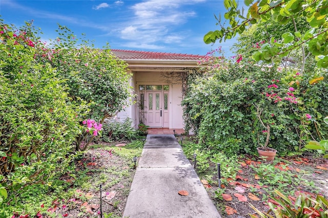 3388 Highlands Bridge Rd, Sarasota, FL 34235 - view of exterior entry with stucco siding and a tiled roof