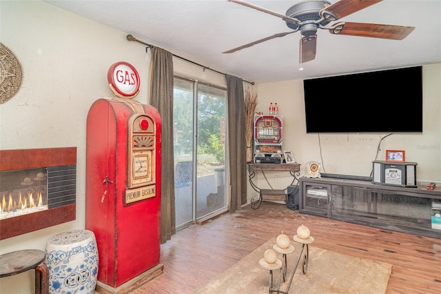 3921 Marlborough Pl, Sarasota, FL 34241 - living room with wood finished floors, a ceiling fan, and a lit fireplace