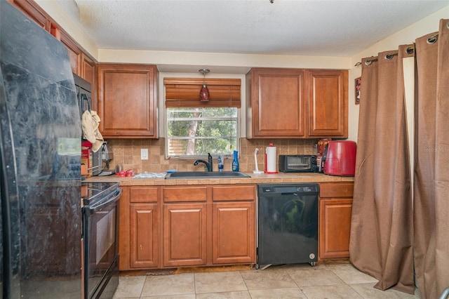 3921 Marlborough Pl, Sarasota, FL 34241 - kitchen with black appliances, a sink, light countertops, decorative backsplash, and a textured ceiling