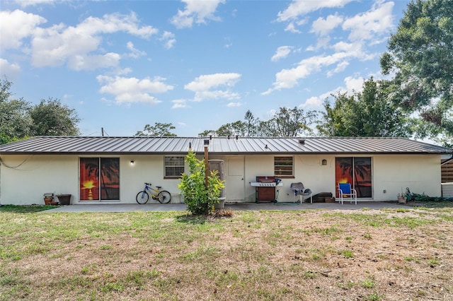 3921 Marlborough Pl, Sarasota, FL 34241 - back of property featuring a patio area, metal roof, and a lawn