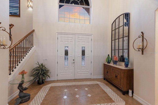801 3rd St E, Palmetto, FL 34221 - foyer entrance featuring a towering ceiling, tile patterned flooring, baseboards, and stairs