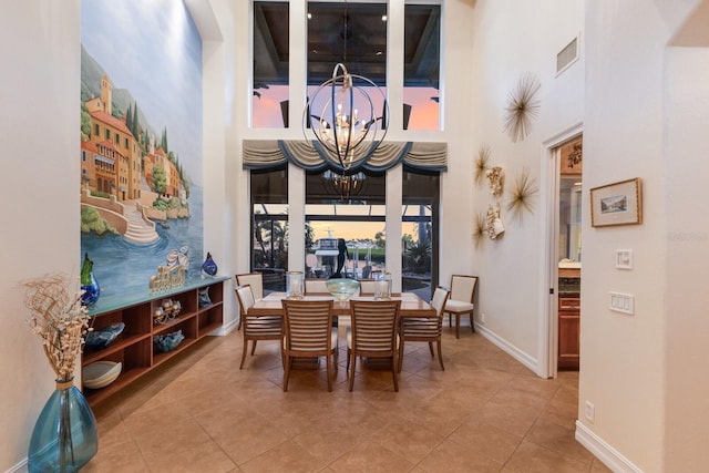 801 3rd St E, Palmetto, FL 34221 - dining space featuring a towering ceiling, a chandelier, tile patterned floors, and baseboards
