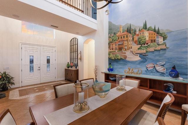 801 3rd St E, Palmetto, FL 34221 - dining area with tile patterned floors, a towering ceiling, arched walkways, and baseboards