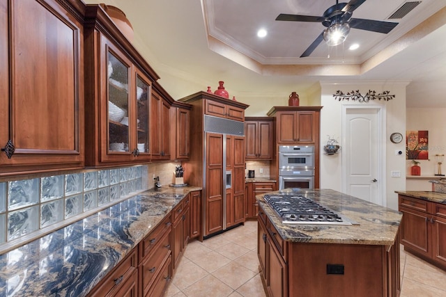 801 3rd St E, Palmetto, FL 34221 - kitchen featuring stainless steel appliances, backsplash, a raised ceiling, light tile patterned floors, and ornamental molding