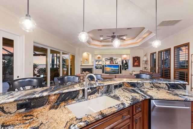 801 3rd St E, Palmetto, FL 34221 - kitchen with a sink, crown molding, brown cabinets, a lit fireplace, and open floor plan