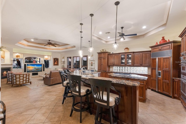 801 3rd St E, Palmetto, FL 34221 - kitchen featuring ceiling fan, a tray ceiling, a center island with sink, crown molding, and recessed lighting