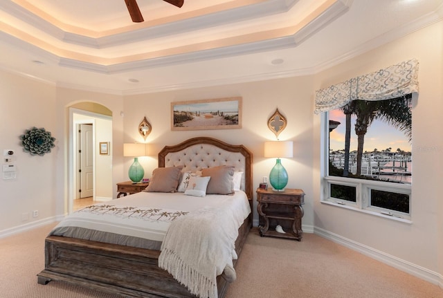 801 3rd St E, Palmetto, FL 34221 - carpeted bedroom featuring a raised ceiling, crown molding, arched walkways, a ceiling fan, and baseboards